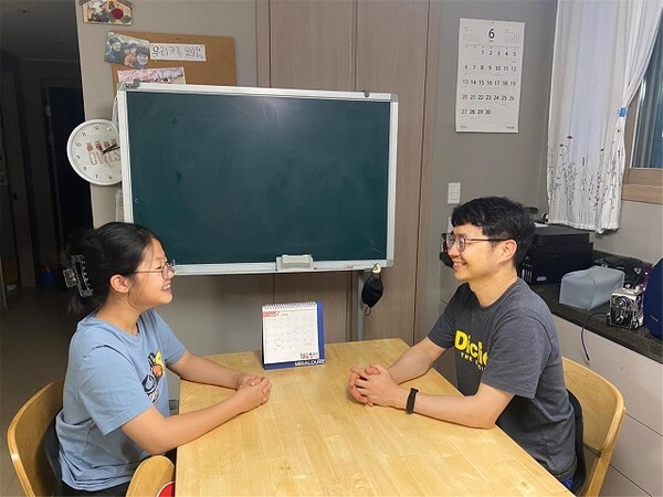 거실 식탁에 앉아 대화를 나누고 있는 아빠와 딸