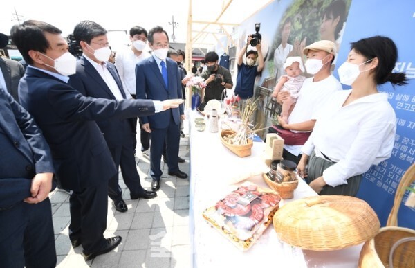 2021년 청년마을 합동 발대식이 30일 완주군 고산미소시장에서 전국 15개 청년마을이 참가해 열려 행사에 참석한 전해철 행정안전부장관과 송하진 도지사, 박성일 완주군수 등이 완주 청년농부 진남현. 황포도 부부와 이야기를 나누고 있다. /사진 = 오세림 기자