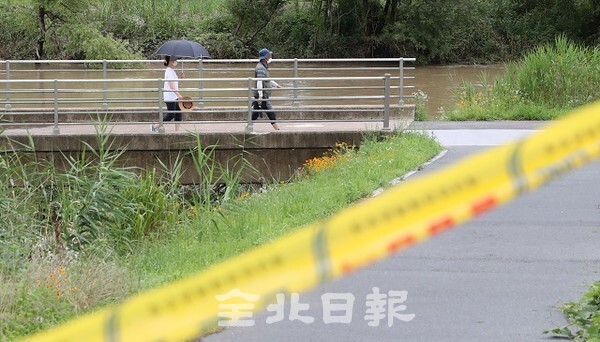 장맛비로 하천 수위가 높아져 출입이 금지된 8일 전주시 삼천천에서 일부 시민들이 천변에서 산책을 하고 있다. /사진 = 조현욱 기자