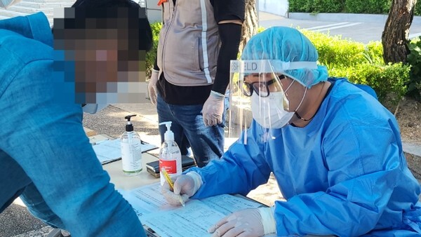 23일 오전 익산시 보건소 선별진료소 현장에서 방호복 등으로 중무장한 송승욱 기자가 문진표 작성 안내를 하고 있다.