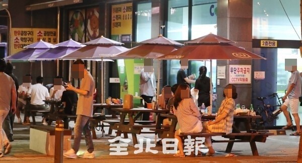 전북지역 사회적 거리두기 2단계 적용으로 유흥시설과 노래연습장 등 술집이 24시까지 운영을 제한하는 가운데 24일 일부시민들이 전주시 신시가지에서 제한시간을 넘기자 편의점으로 넘어와 술자리를 이어가고 있다. /사진 = 조현욱 기자
