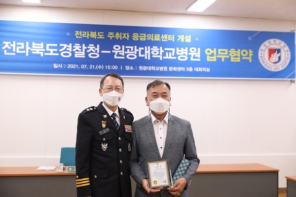 익산경찰서 양양규 경위(오른쪽)가 주취자 응급의료센터 개소를 위한 전북경찰청과 원광대학교병원간 업무협약식에서 이형세 전북경찰청장으로부터 표창장을 받았다.