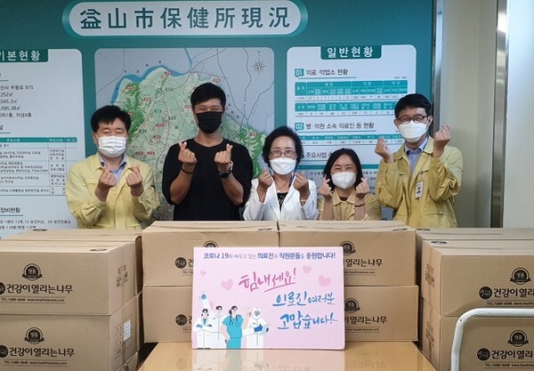 익산 석공예 명장인 강현녀 천일석재 대표(가운데)가 27일 익산시보건소에 400만원 상당의 건강음료를 전달했다.