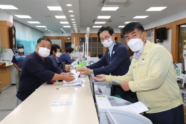 유기상 고창군수가 7일 은행에서 농민들에게 농어민공익수당 지급을 안내하고 있다.