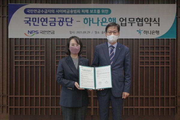 9일 하나은행 본점에서 국민연금공단 김정학 연금이사(오른쪽)와 하나은행 김소정 부행장(왼쪽)이 ‘사이버금융범죄 피해 예방’ 업무협약 체결 후 기념 촬영을 하고 있다. /사진 제공 = 국민연금공단 제공