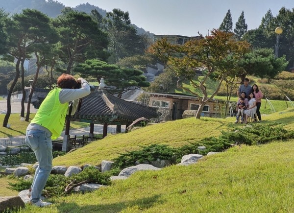 정읍시 건강가정 · 다문화가족지원센터 관계자가 정읍사공원에서 다문화가정의 가족사진을 촬영하고 있다.