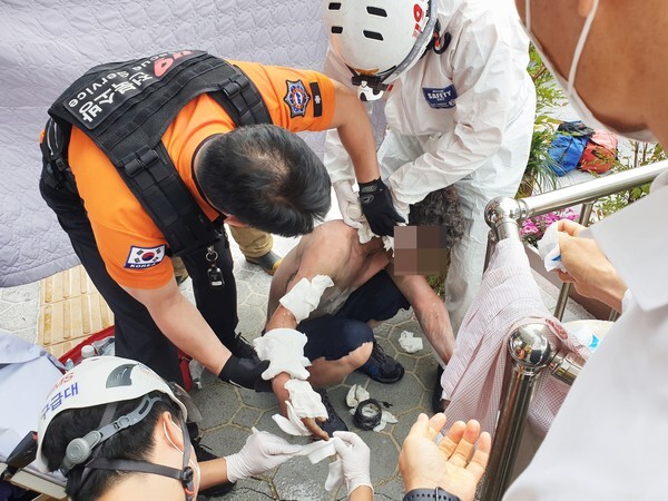 7일 오전 11시께 40대 남성이 익산시청 본관 현관 앞에서 분신을 시도해 119 신고를 받고 출동한 구급대원들이 소독과 드레싱 등 응급처치를 하고 있다.