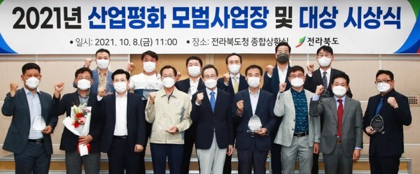 지난 8일 전북도청 종합상황실에서 열린 2021년 산업평화 모범사업장 및 산업평화 대상 시상식에서 송하진 도지사가 산업평화 모범사업장 6곳과 산업평화 대상 3명에게 시상을 하고 기념촬영을 하고 있다.