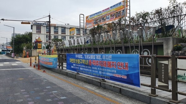 이리북일초등학교 도로변에 '어린이 보호구역 내 홀짝주차제 폐지 안내'현수막이 걸려 있다.