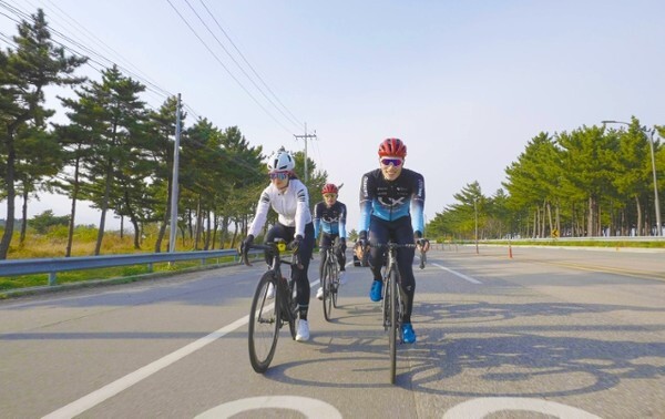 LX사이클 선수단 장선재 코치(오른쪽)와 선수들이 사이클 유튜버 조아라 씨(왼쪽)와 강원도 양양군 해변길에서 라이딩을 하고 있다. /사진 제공 = 한국국토정보공사