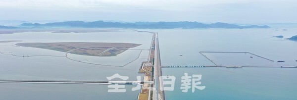 새만금 신항만 시설과 배후부지가 서서히 윤곽을 들어내고 있다. 지난 30일 새만금 방조제를 가운데 두고 왼쪽으론 동서도로를 지나 배후부지가 메워지고 있고 오른쪽으로 신항만 공사가 한창 진행되고 있다. /사진 = 오세림 기자