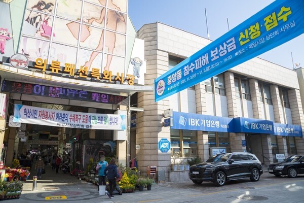 익산 중앙동 거리에 침수피해 보상금 신청 · 접수를 알리는 현수막이 게침되어 있다.