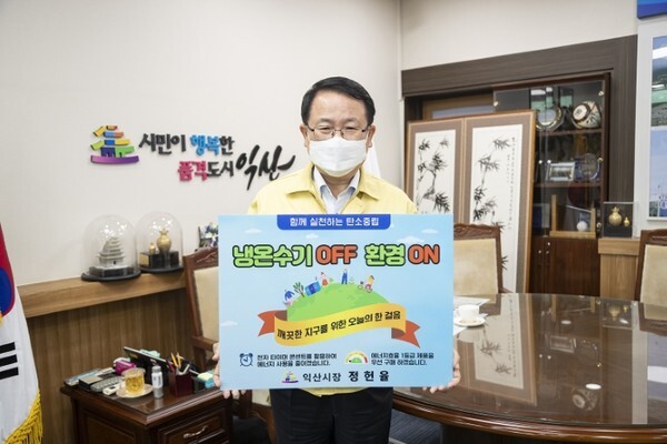 ‘생활 속 에너지 절약 실천 챌린지’에 참여한 정헌율 익산시장이 피켓을 들고 사진을 촬영하고 있다.
