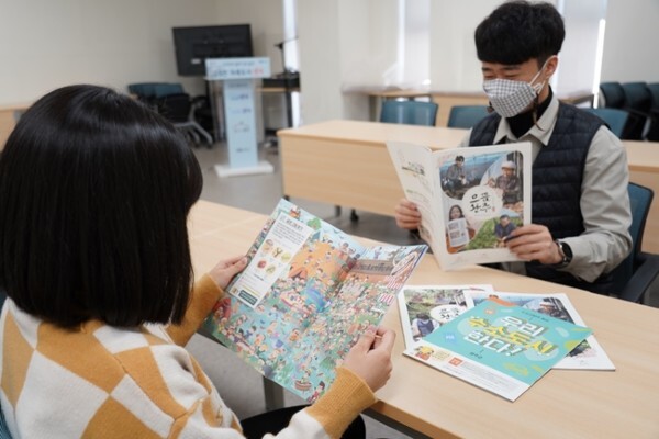 완주군민들이 완주군정소식지 '으뜸완주'를 보고 있다.