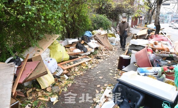 전주시 견훤왕궁로 인도에 불법쓰레기가 쌓여 지나는 28일 시민들의 통행까지 방해하고 있다. /사진 = 오세림 기자