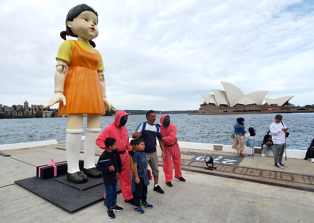 올해 지구촌은 방탄소년단(K팝)과 '오징어 게임'(드라마), '미나리'(영화) 등 K-컬처 열기로 뜨거웠다. 사진은 지난 11월 1일 호주 시드니의 명소 오페라 하우스와 하버 브리지 사이에 '무궁화꽃이 피었습니다' 게임의 술래 '영희' 인형과 분홍색 제복의 진행 요원 등 '오징어 게임' 체험장이 설치된 모습. /연합뉴스