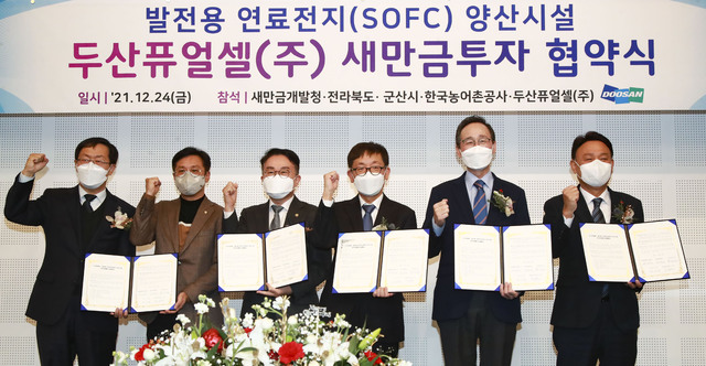 두산퓨얼셀㈜ 새만금 투자 협약식이 지난 24일 군산 은파팰리스에서 열린 가운데 참석자들이 기념촬영을 하고 있다. 왼쪽부터 김우상 한국농어촌공사 단장, 신영대 국회의원, 양충모 새만금개발청장, 제후석 두산퓨얼셀㈜ 전무, 송하진 전북도지사, 강임준 군산시장./ 사진=전북도 제공