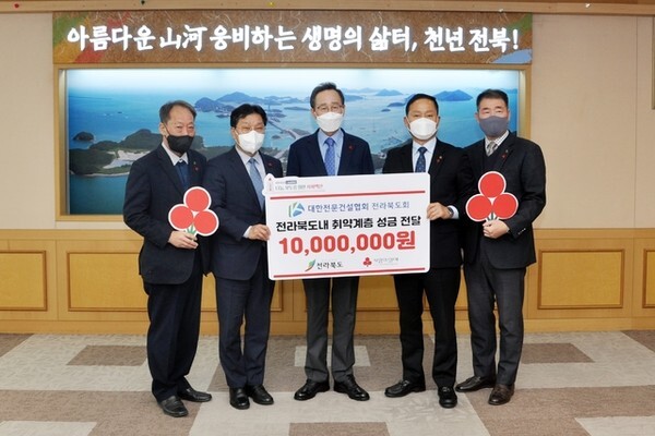 대한전문건설협회 전북도회가 지난 13일 전북도청을 방문해 송하진 도지사를 만나 이웃돕기 성금을 전달하고 있다./사진 =전문건설협회 전북도회 제공.