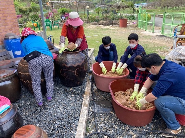 아이들이 독에서 커낸 된장을 으깨는 작업을 하고 있다. 사진/완주군