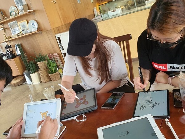 2021년 청년동아리 활성화 사업 지원을 받은 완주 청년동아리 회원들이 보드에 그림을 그리고 있다.